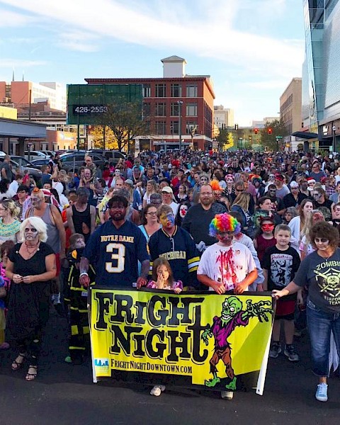 A crowd dressed in costumes, holding a yellow 