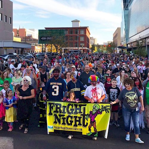 A crowd dressed in costumes, holding a yellow 