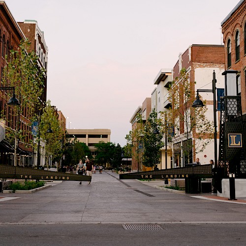 A quiet urban street with historic buildings on both sides; signs read 